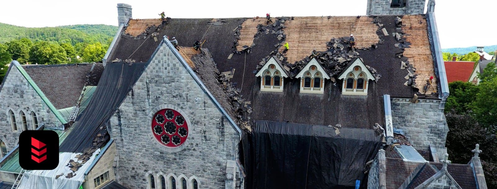 Stone church with a shingle tear-off in progress