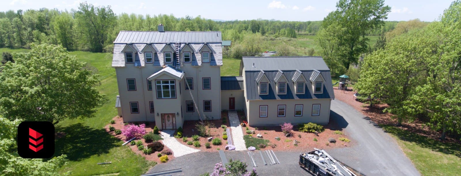 Aerial view of a large home getting an Englert charcoal standing-seam metal roof